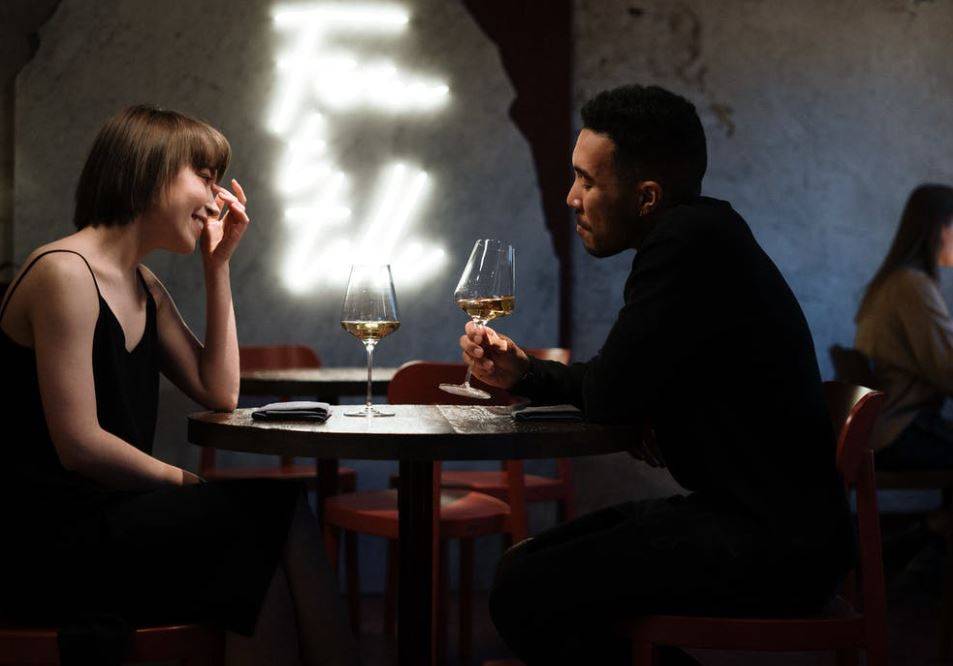Ein Paar genießt ein romantisches Dinner mit Wein in einem stilvollen Restaurant in Frankfurt.