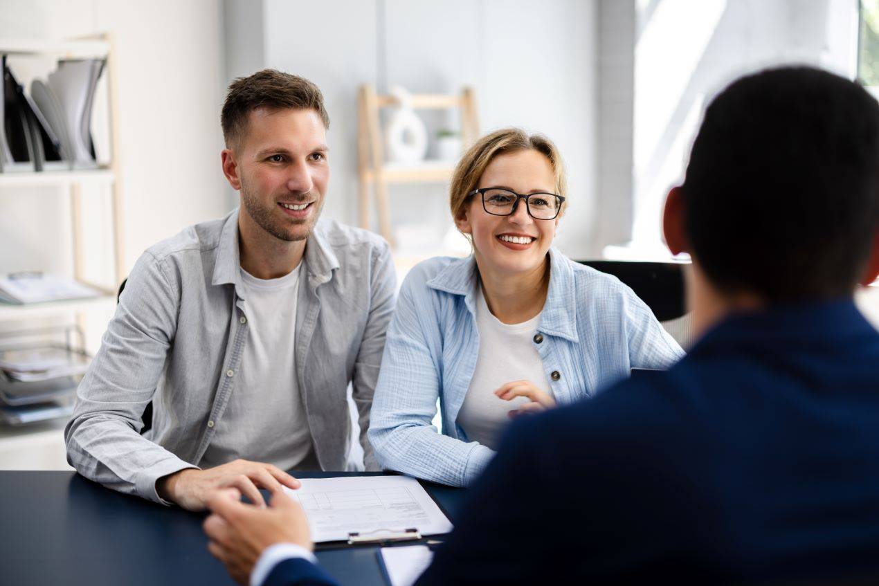 Ein glückliches Paar im Gespräch mit einem Steuerberater aus Neu-Ulm für eine professionelle Finanz- und Steuerberatung.