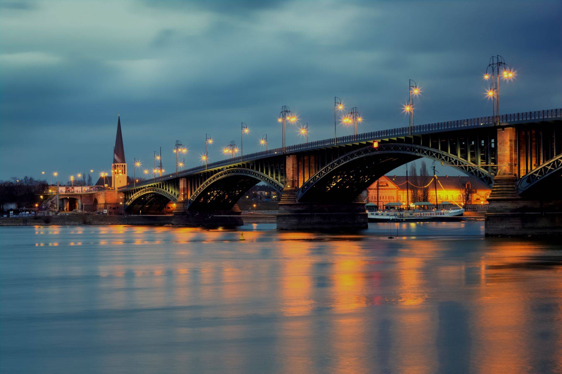 Beleuchtete Rheinbrücke in Mainz bei Nacht, stimmungsvolle romantische Atmosphäre.